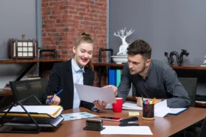 two-corporate-professionals-learning-english-together-in-an-office-with-hrdf-sponsorship